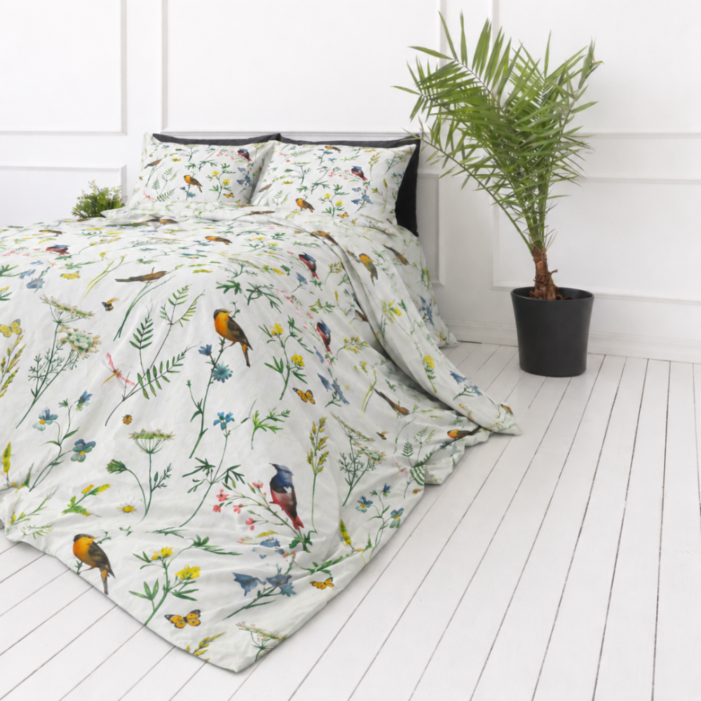 Bedding Set „Song Nest“. Patterned bedding sets, 140x200 cm, 200x200 cm, 200x220 cm. Watercolor-style birds, green branches, and delicate blossoms shine against the background of light white bedding.